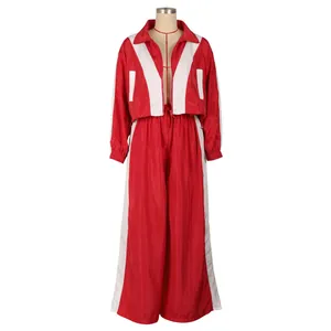 Zweiteiliger Trainingsanzug in Rot und Weiß mit gewebter Jacke und weiter Hose.