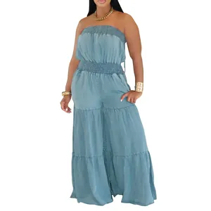 Detailed view of light blue strapless smocked denim jumpsuit with tiered wide legs.