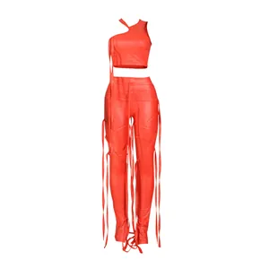 Dettaglio completo di un set due pezzi rosso sexy con lacci e pantaloni in ecopelle