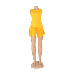 Detailed view of a vibrant yellow two-piece summer set with fringe trim on shorts