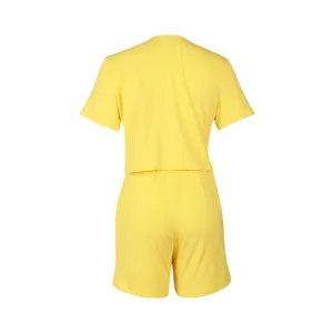 Vista posteriore dettagliata del set sportivo giallo a due pezzi in costina con t-shirt e pantaloncini