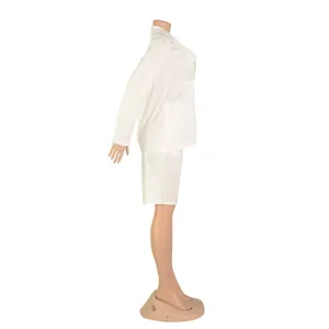 Detalle de perfil lateral de un traje blanco de dos piezas con blazer y pantalones cortos