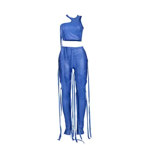 Dettaglio del set due pezzi in ecopelle blu elettrico con cinturini decorativi pendenti