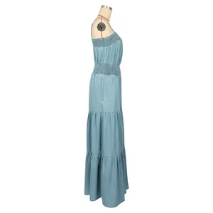 Side view of light blue denim sleeveless jumpsuit with smocked waist and tiered hem.