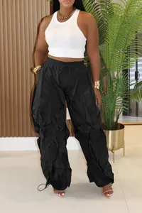 Close-up of black pleated wide-leg casual trousers for women in a stylish lifestyle setting.