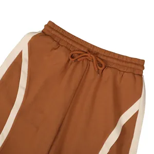 Detail view of brown cotton sweatpants showing elastic waistband and drawstring.