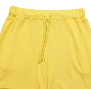 Primo piano di pantaloncini sportivi a coste gialli con vita elastica e coulisse