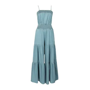 Sleeveless light blue denim tiered jumpsuit featuring a smocked bodice and wide legs