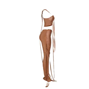 Profilo laterale di un set due pezzi in ecopelle marrone con crop top e pantaloni abbinati