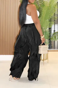 Detail view of black wide-leg trousers with unique ruffled and pleated textures.
