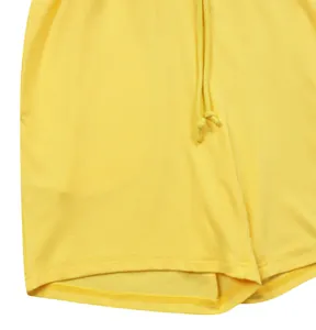 Dettaglio dei pantaloncini sportivi in maglia a costine gialle con coulisse e cuciture