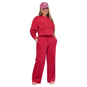 Detail view of red women's two-piece tracksuit featuring long sleeve hoodie and wide-leg pants.