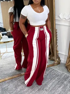 Pantalon large rouge et blanc moderne porté par un mannequin dans un studio élégant