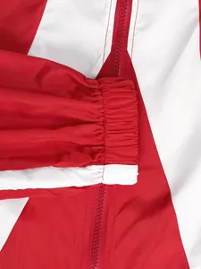 Nahaufnahme einer rot-weißen Trainingsjacke mit elastischem Bündchen und Reißverschluss