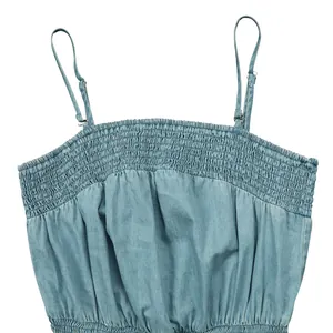 Close-up detail of smocked denim jumpsuit bodice with adjustable spaghetti straps
