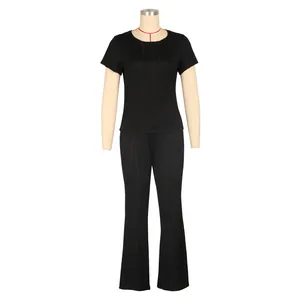 Détail d'un ensemble deux pièces noir avec haut à manches courtes et pantalon évasé plissé
