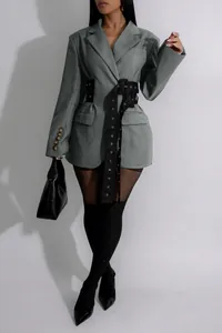 Detailed macro view of a gray women's blazer featuring unique black buckled waist straps