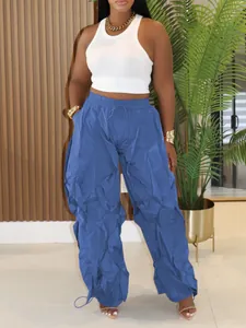 Detail view of blue ruched wide-leg trousers with drawstring waist and relaxed fit.