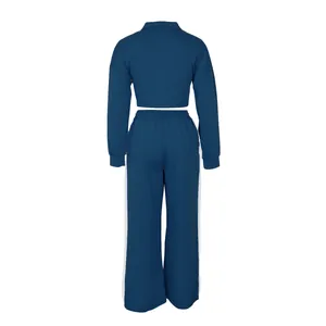Back view of blue women's two-piece athletic sweat suit with white side stripes.