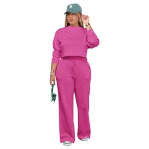Two-piece magenta tracksuit with crop sweatshirt and wide-leg pants on white background