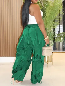 Detailed view of emerald green wide-leg ruffled pleated trousers from a back angle