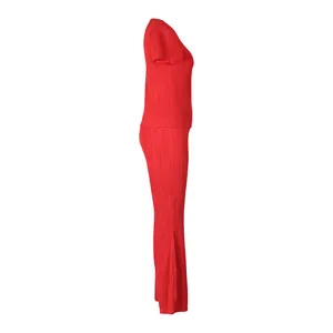 Vue latérale d'un ensemble plissé rouge deux pièces avec haut à manches courtes et pantalon
