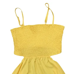 Detail shot of yellow smocked dress with adjustable spaghetti straps and waist cut-out
