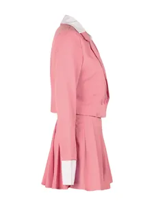 Side profile of women's pink two-piece set featuring cropped blazer and pleated skirt.