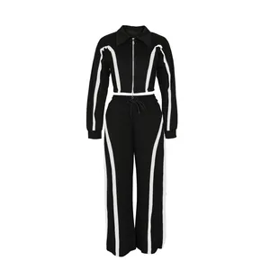 Two-piece black and white athletic tracksuit set with zip jacket and pants