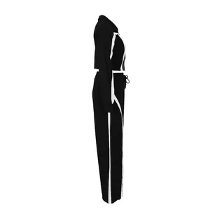 Side view detail of women's black 2-piece tracksuit with contrasting white stripes