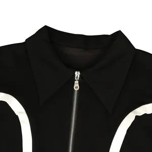Close-up of black sporty jacket featuring sharp collar and white contrast piping detail