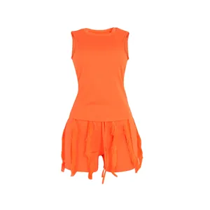 Detailed view of vibrant orange two-piece summer set with fringe tank top and shorts