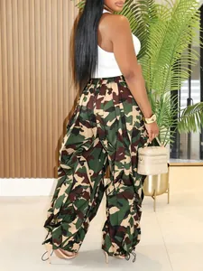 Detailed view of women's camouflage print wide-leg trousers with pleated ankle design.
