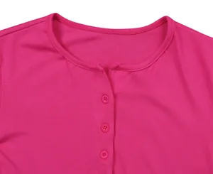 Dettaglio del tessuto fucsia a costine e bottoni rosa su un capo con scollo rotondo