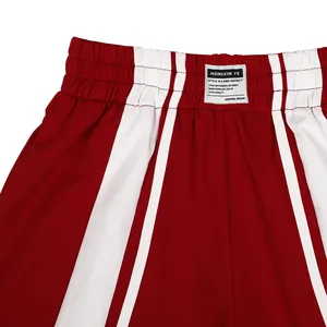 Gros plan du pantalon à rayures rouges et blanches avec taille élastique et étiquette tissée.