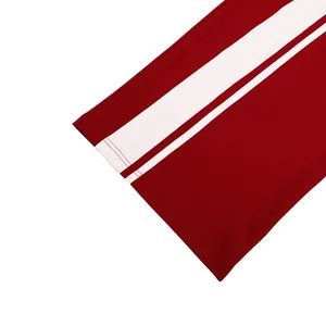 Détail en gros plan d'un pantalon large rouge avec bandes latérales blanches et coutures