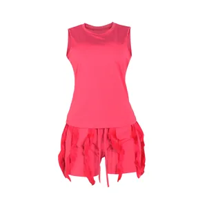 Detailed view of hot pink two-piece summer outfit featuring sleeveless top and fringe shorts.