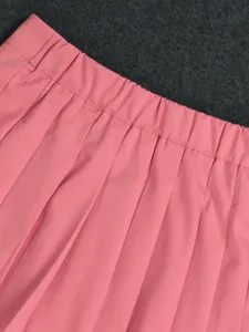 Detail shot of pink pleated suit skirt waistband with elastic design and neat pleats.