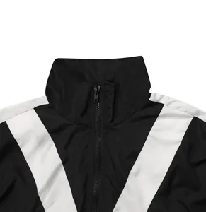 Detailaufnahme von Reißverschluss und Kragen der schwarz-weißen Webjacke in Kontrastfarben