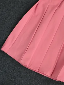 Close-up of pink pleated skirt detailing showing fine fabric texture and neat stitching