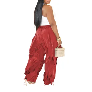 Back view of stylish red pleated wide-leg trousers on model paired with white top