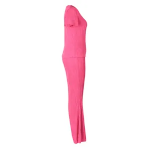 Vue de profil d'un ensemble deux pièces plissé rose avec haut court et pantalon.