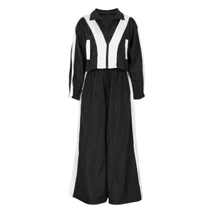 Damen Sportanzug Set mit bauchfreier Jacke und weiter Hose im modernen Schwarz-Weiß Kontrast