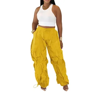 Detail of women's mustard yellow pleated cargo pants with drawstring waist for casual wear.