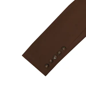 Detailed close-up of a brown blazer jacket sleeve featuring five decorative buttons