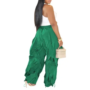 High-waist pleated wide-leg trousers in vibrant green with crinkled texture for women.