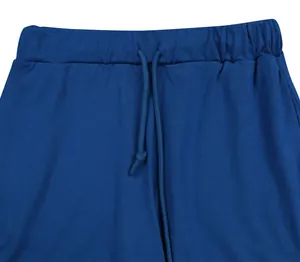 Dettaglio ravvicinato di pantaloncini sportivi blu in maglia a costine con coulisse.
