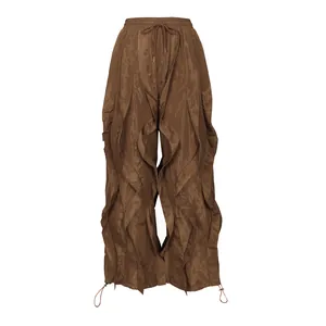 Detailed view of brown wide-leg trousers with unique ruffled panels and drawstring waist