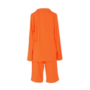 Vista trasera de un conjunto informal naranja para mujer de americana y pantalones cortos