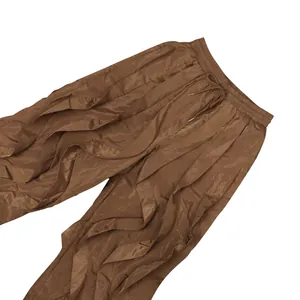 Detailed view of brown ruffled wide-leg trousers with drawstring waist and silky texture